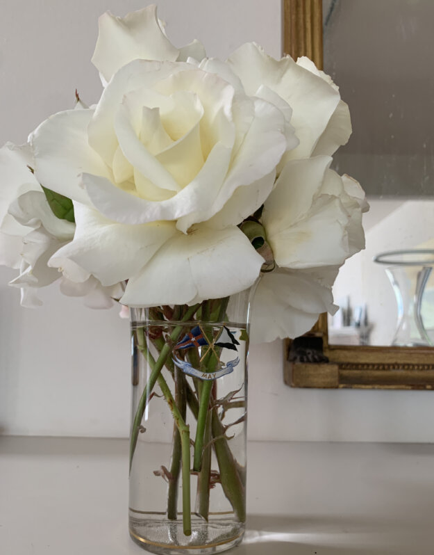 A glass tumbler painted with a pennant inscribed SS May and two flags, with white roses