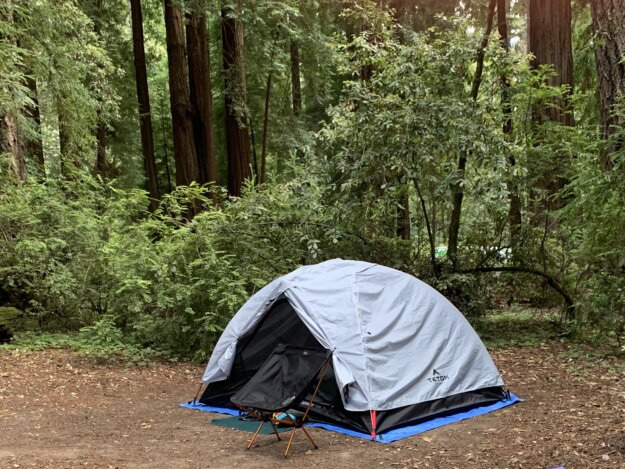 Teton 2-person tent pitched in Memorial Park with a camp chair and camp booties in front of it