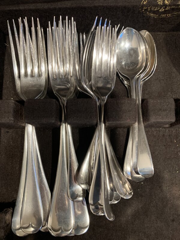 Polished silver forks and spoons in an open box.