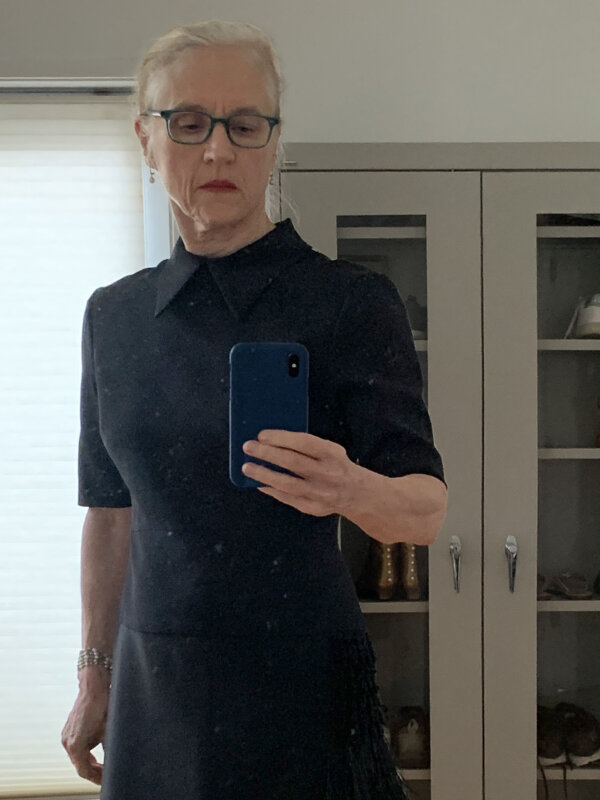 Older woman wearing bright lipstick and a black dress